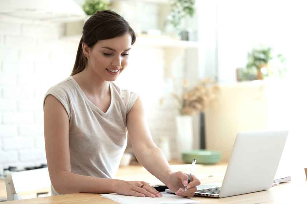 a woman calmly filing her 2022 taxes by the 2023 deadline