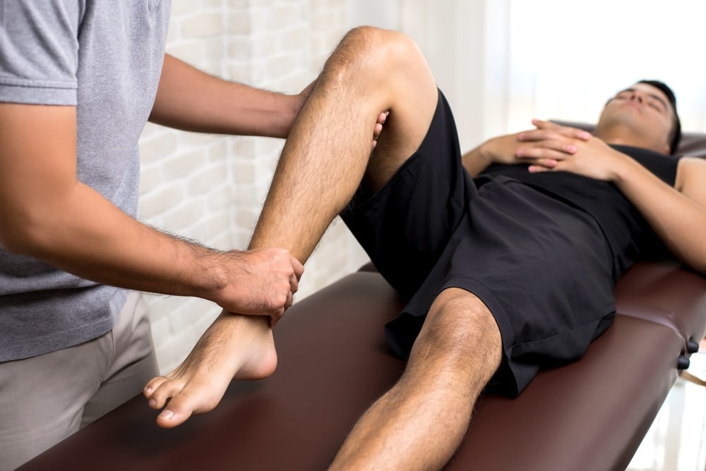 Therapist massaging the leg of an injured patient