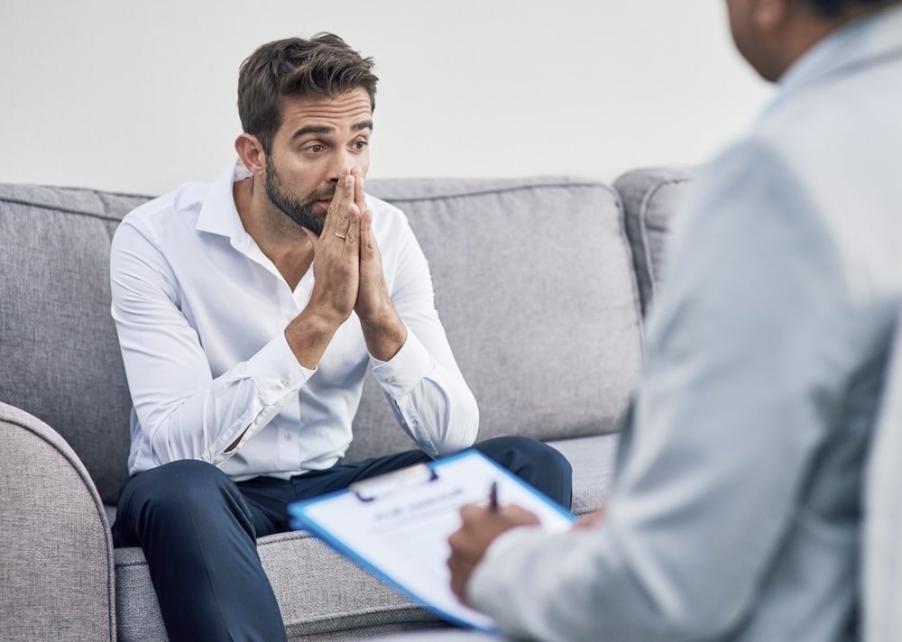 Upset male talking to a therapist in a clinic