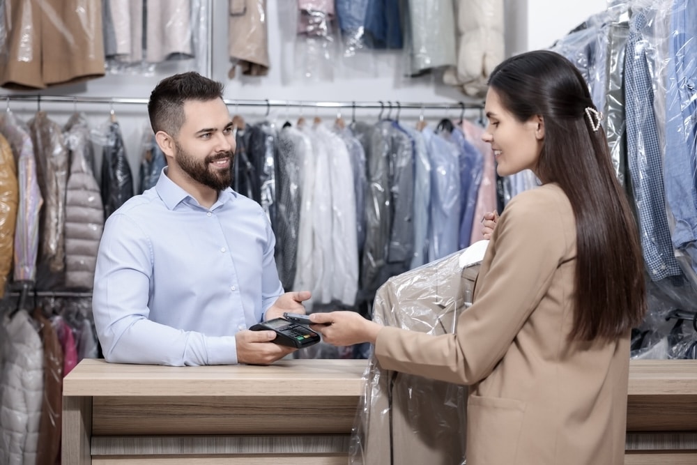 Woman paying a man for dry cleaning service